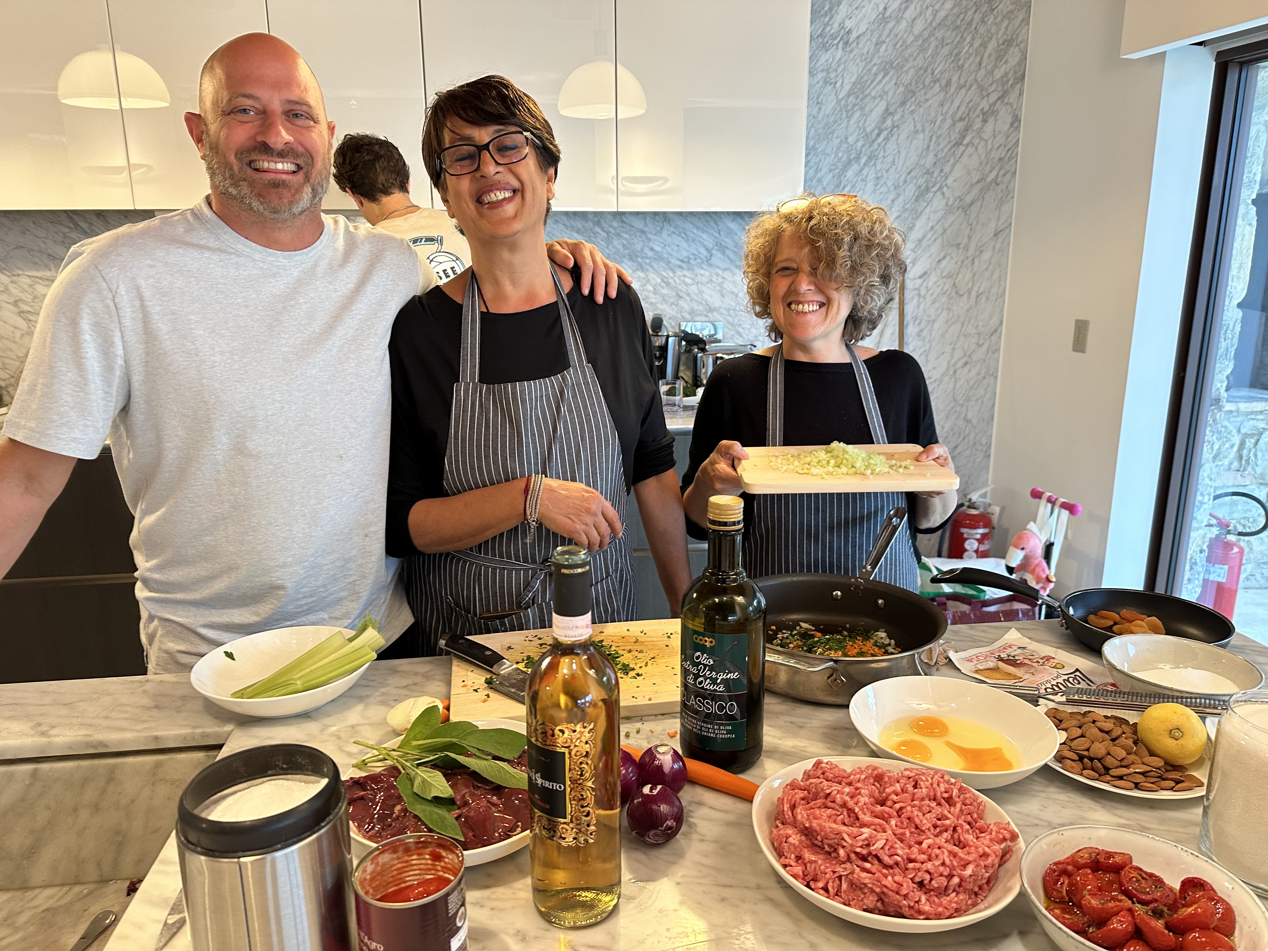 Cooking group in kitchen with ingredients prepared on the counter
